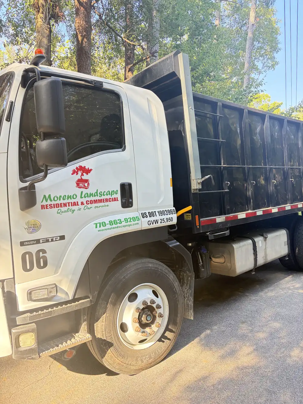 Moreno Landscape dump truck with the company logo and phone number on the door