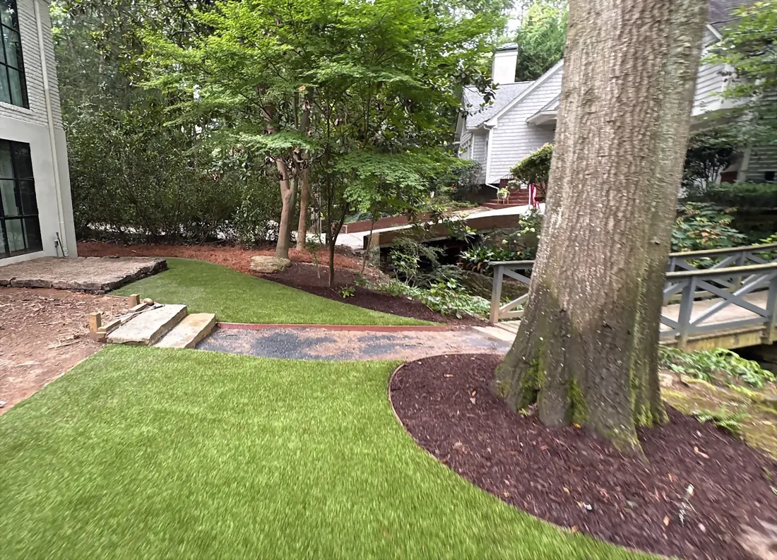 Turf lawn wrapping a mature hardwood with a mulched bed